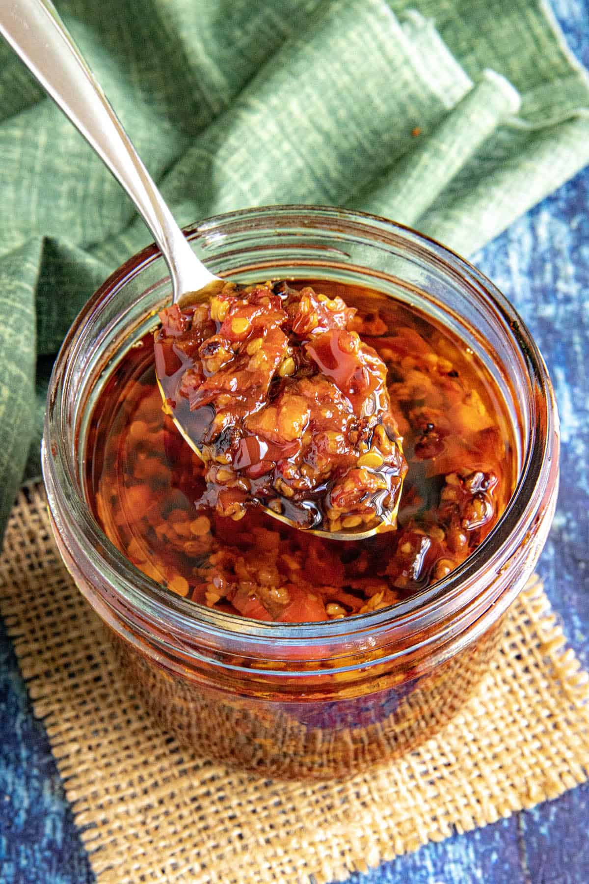 A large spoon of Serrano-Garlic Chili Crunch served from the jar