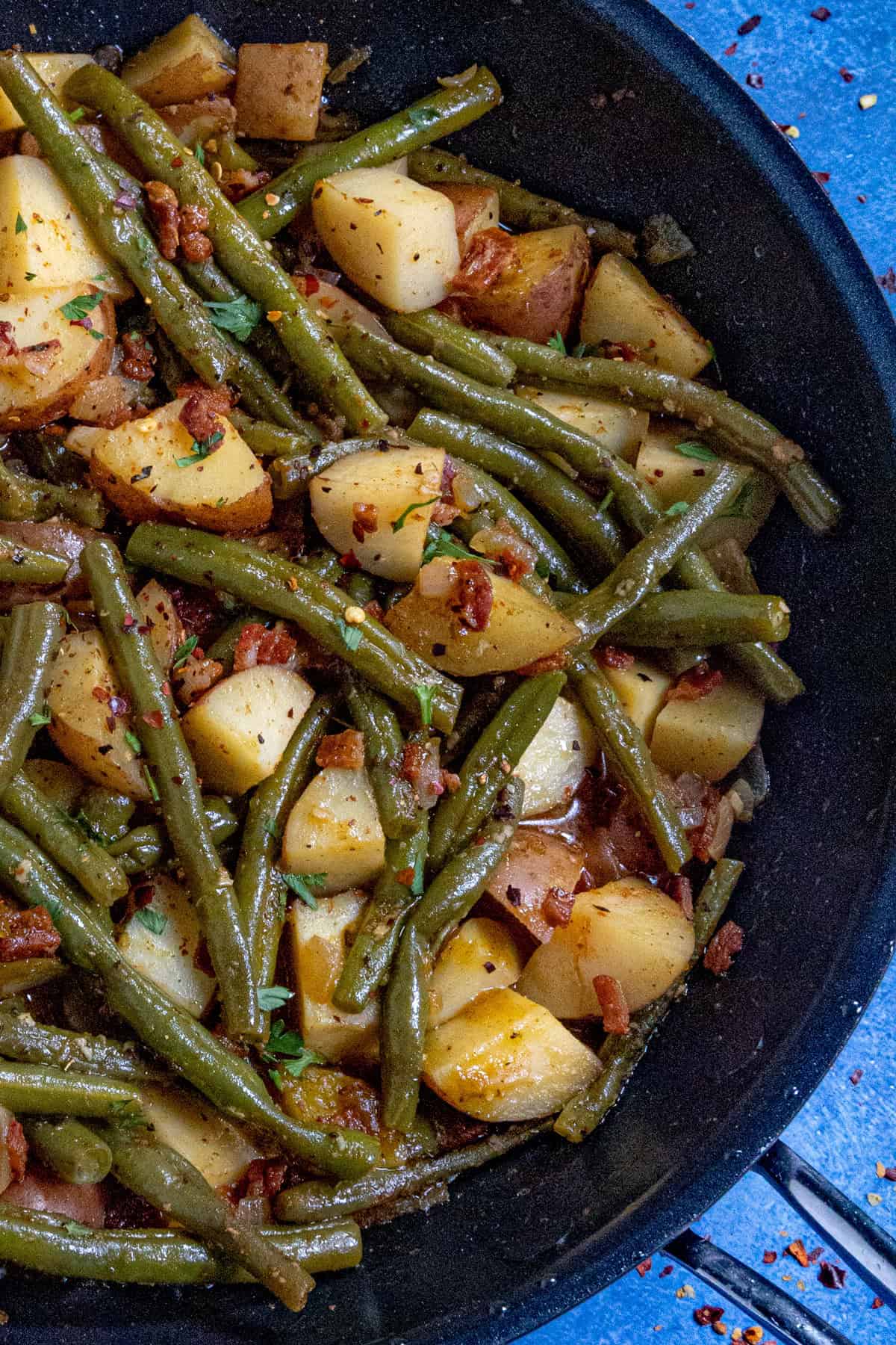 Lots of smothered green beans and potatoes in a pan