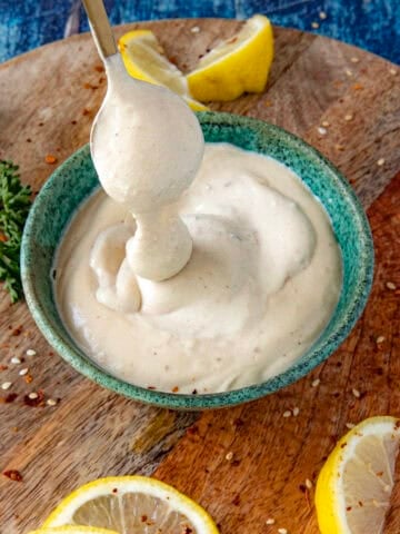 Creamy Tahini Sauce dripping from a spoon