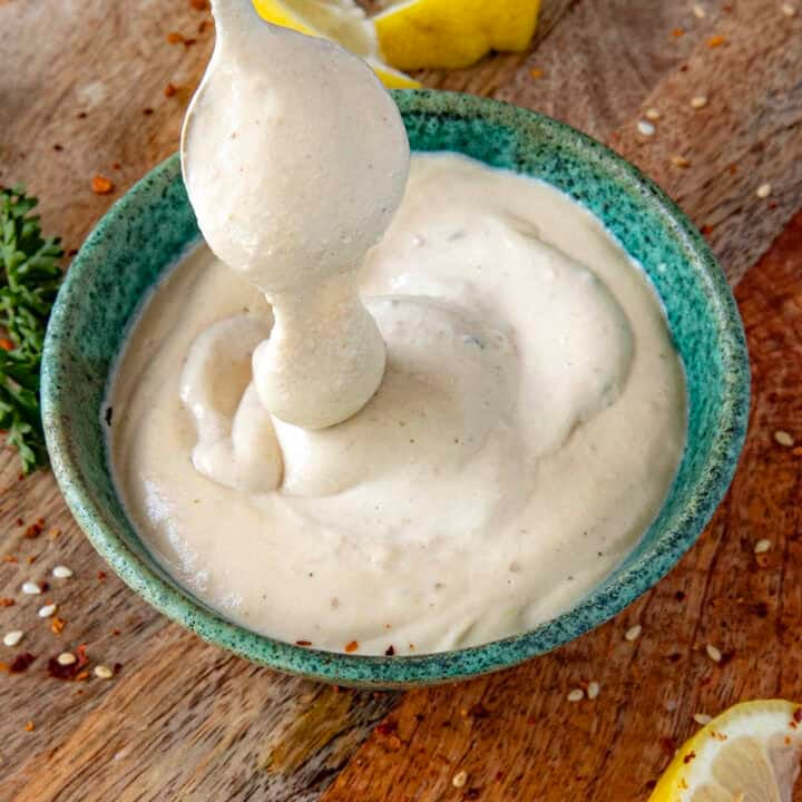 Creamy Tahini Sauce dripping from a spoon