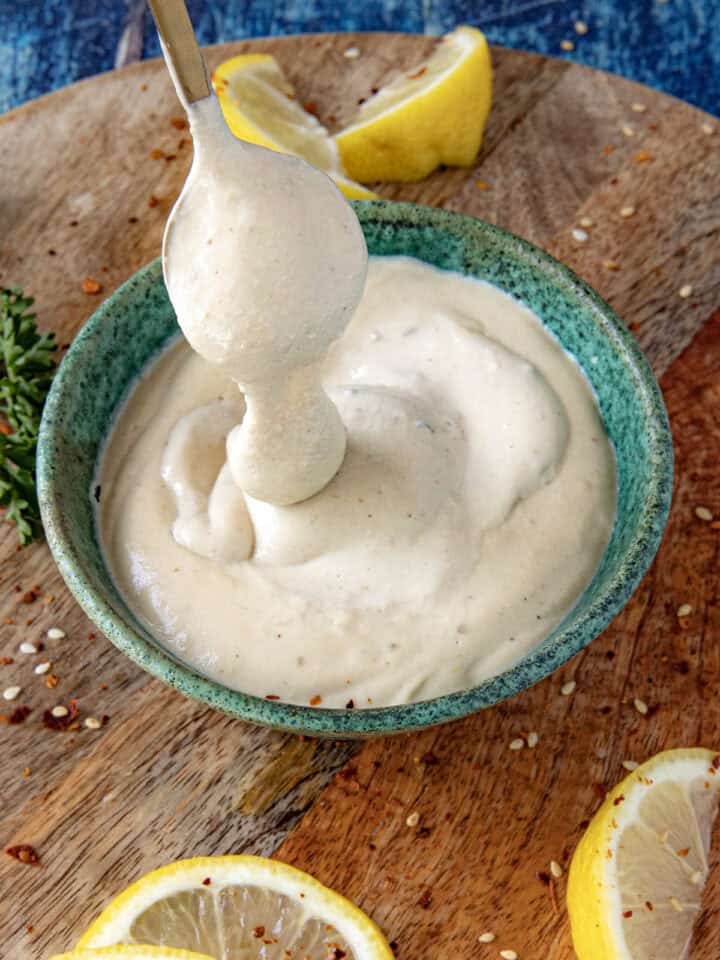Creamy Tahini Sauce dripping from a spoon