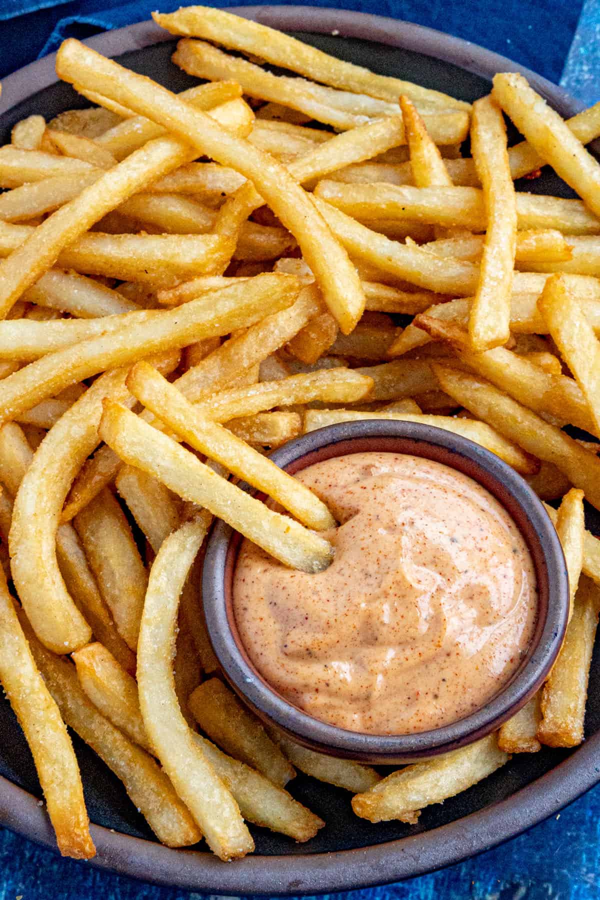 A bowl of creamy fry sauce with french fries protruding from it