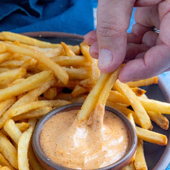 Mike dipping crispy french fries into a bowl of zesty, creamy fry sauce
