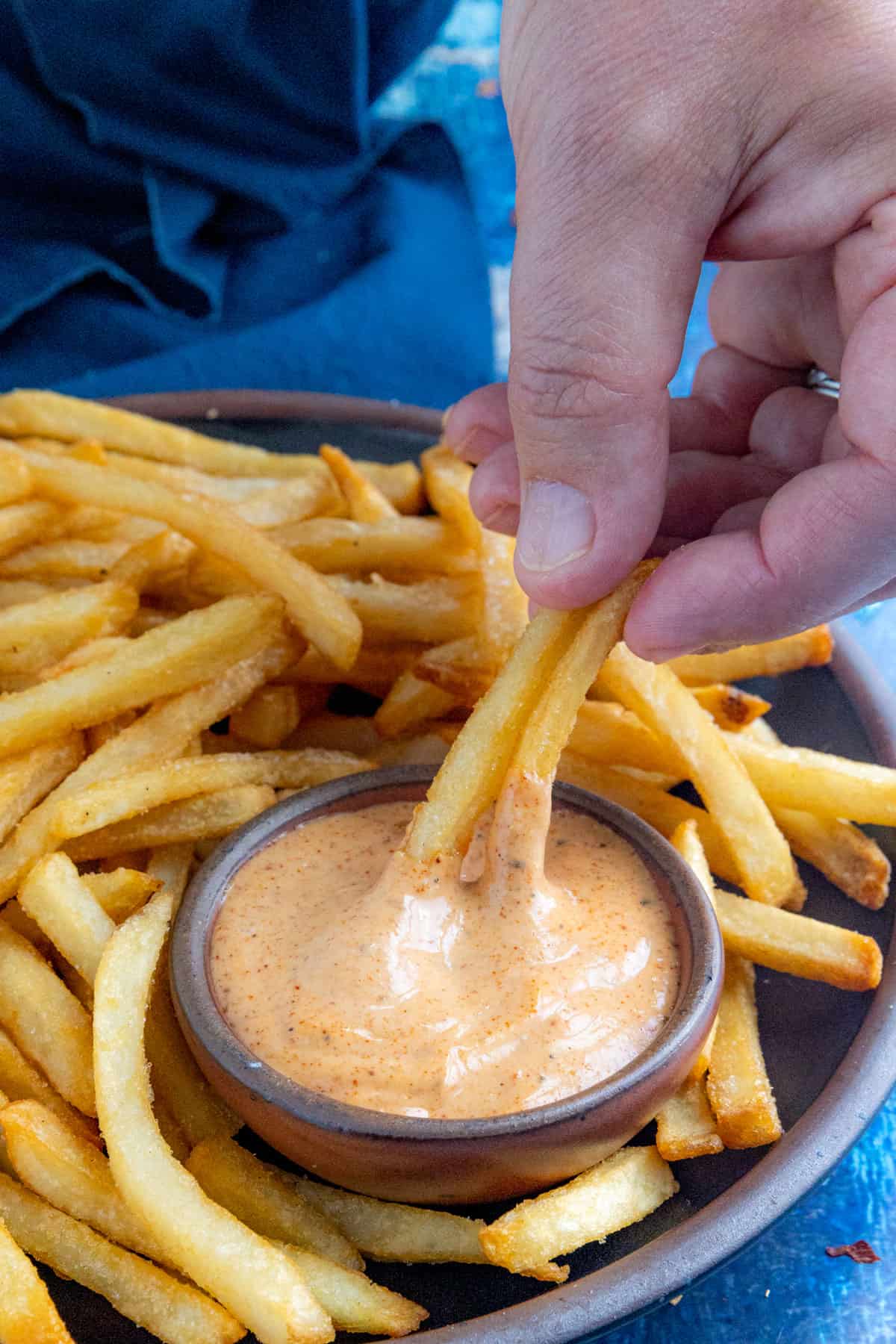 Mike dipping crispy french fries into a bowl of zesty, creamy fry sauce