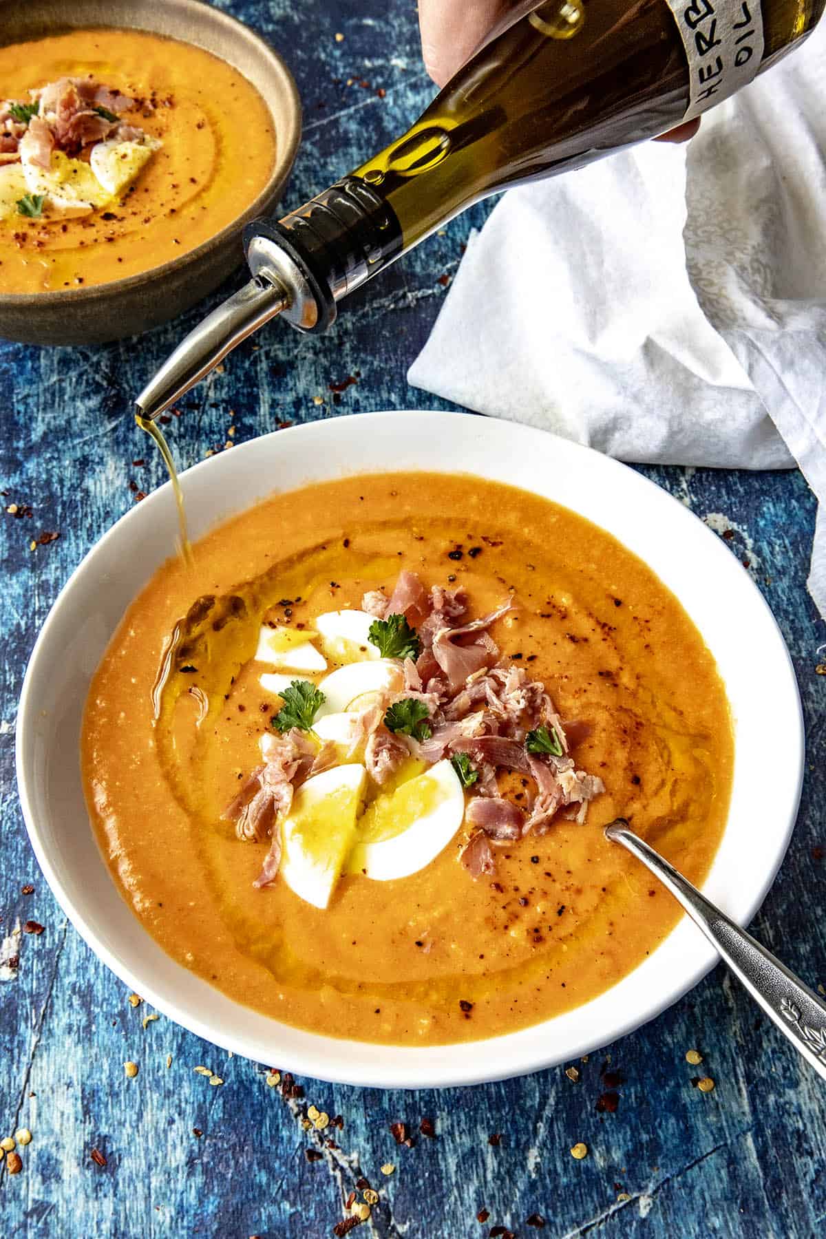 Drizzling fresh herb oil over tomato soup