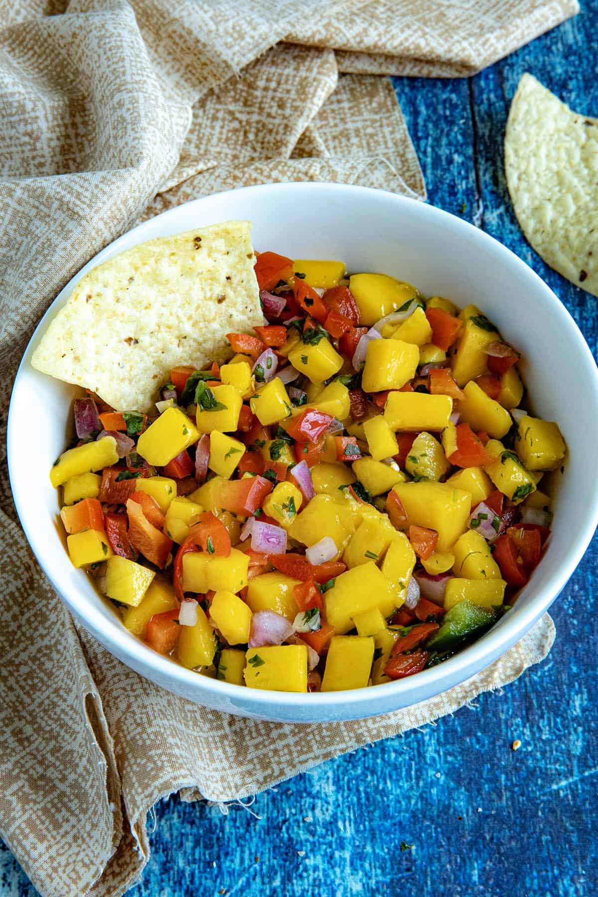 Mango Salsa in a serving bowl with a tortilla chip