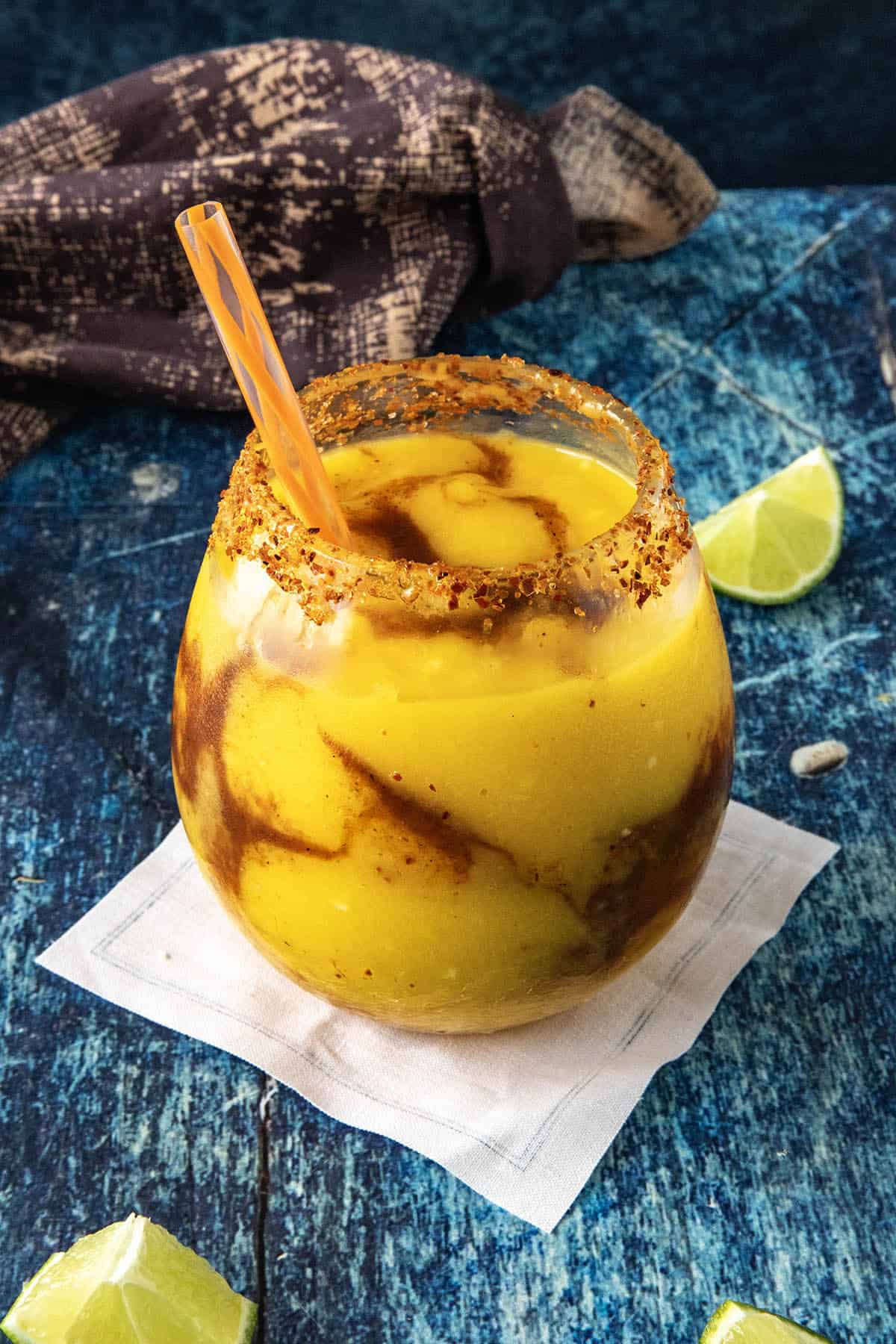 A glass filled with a Mangonada Margarita, ready for you to enjoy