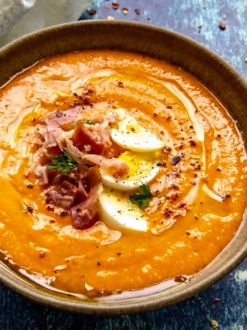 Creamy Salmorejo (Spanish Cold Tomato Soup) garnished with hard boiled egg, sliced ham, and olive oil