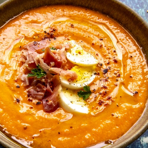 Creamy Salmorejo (Spanish Cold Tomato Soup) garnished with hard boiled egg, sliced ham, and olive oil