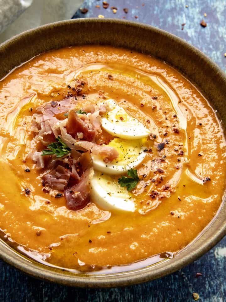 Creamy Salmorejo (Spanish Cold Tomato Soup) garnished with hard boiled egg, sliced ham, and olive oil