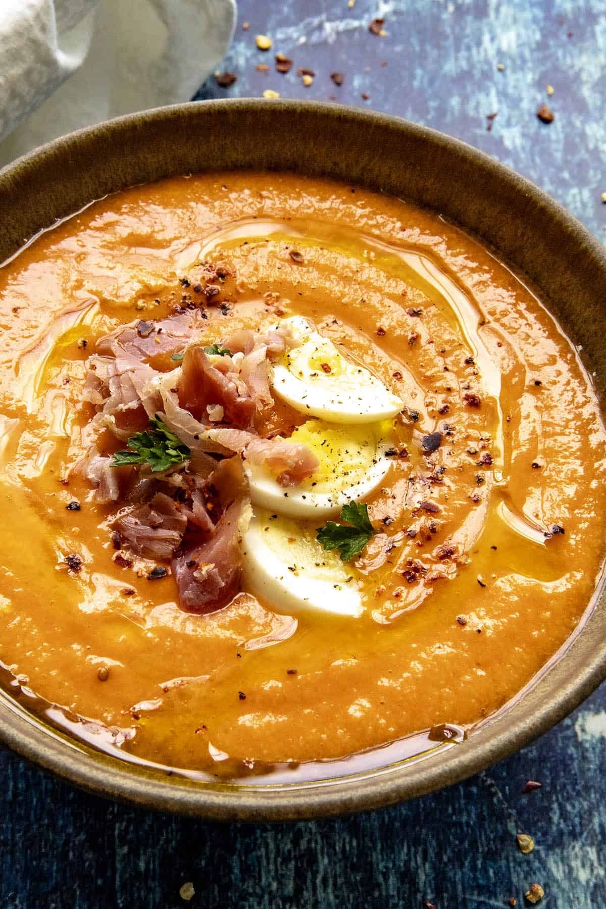 Creamy Salmorejo (Spanish Cold Tomato Soup) garnished with hard boiled egg, sliced ham, and olive oil