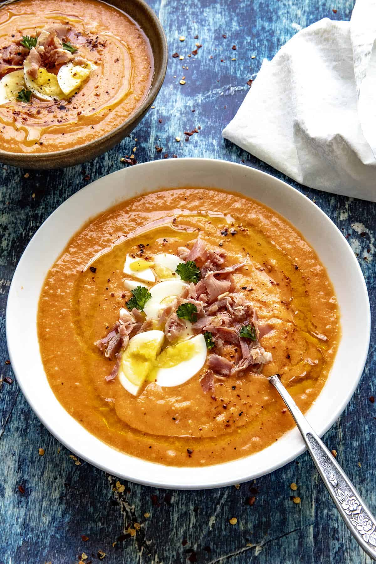 Salmorejo (Spanish Cold Tomato Soup) in a white bowl with garnish