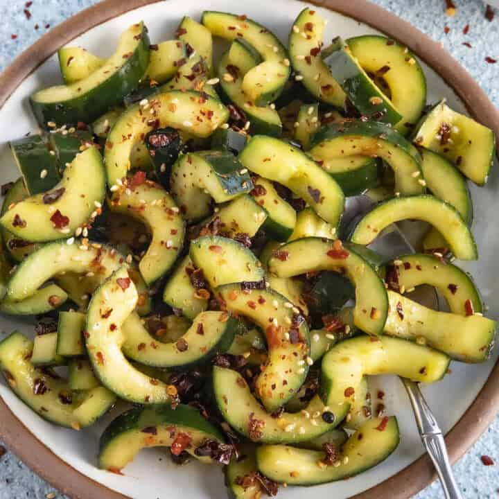 A bowl of Sichuanese Spiced Cucumber Salad (Qiang Huang Gua) garnished with sesame seeds