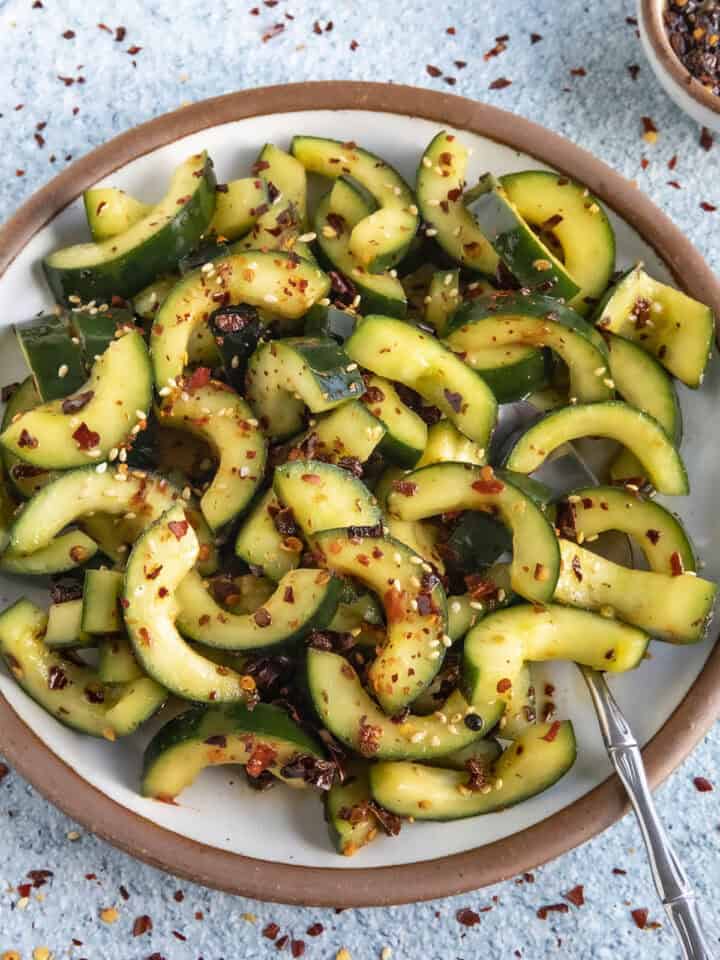 A bowl of Sichuanese Spiced Cucumber Salad (Qiang Huang Gua) garnished with sesame seeds