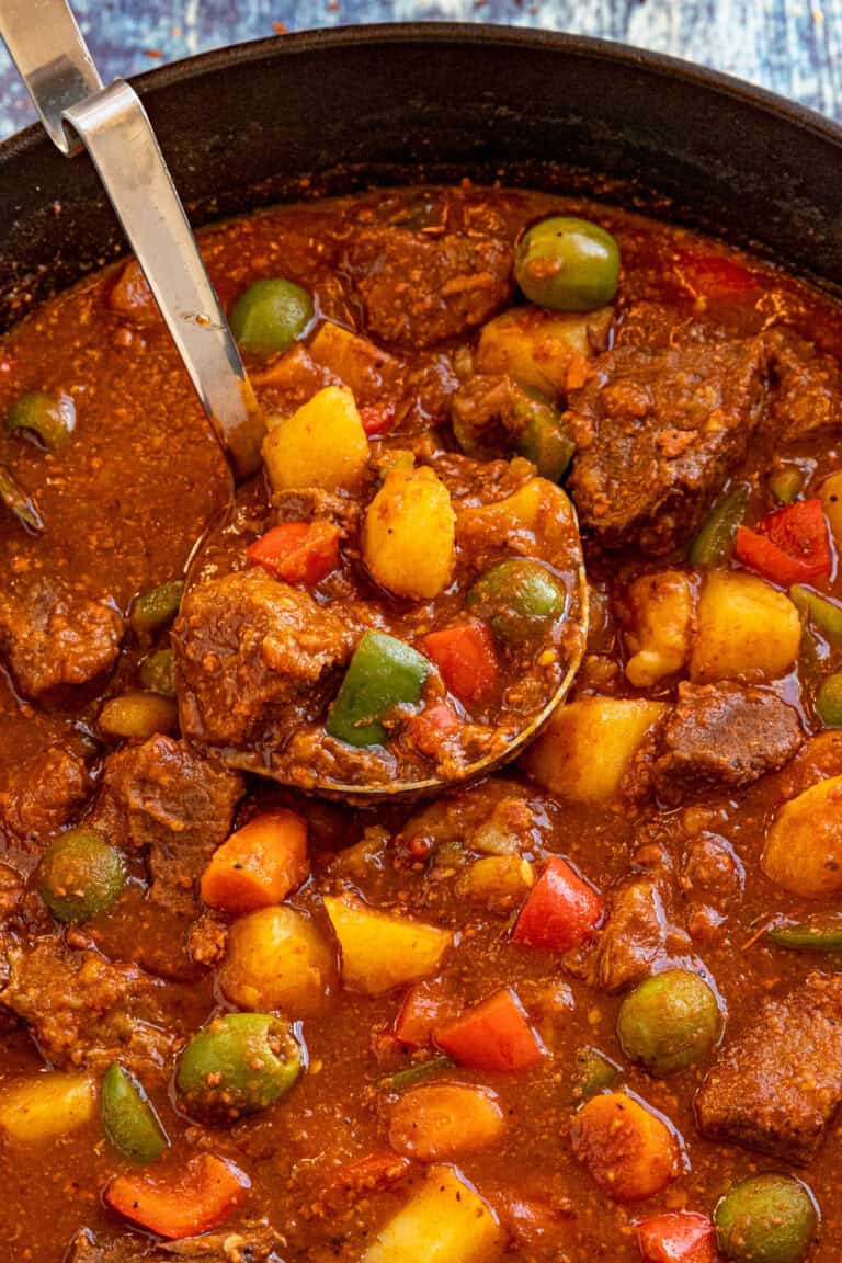 Serving a large ladle full of Beef Caldereta (Filipino Beef Stew) from the pot