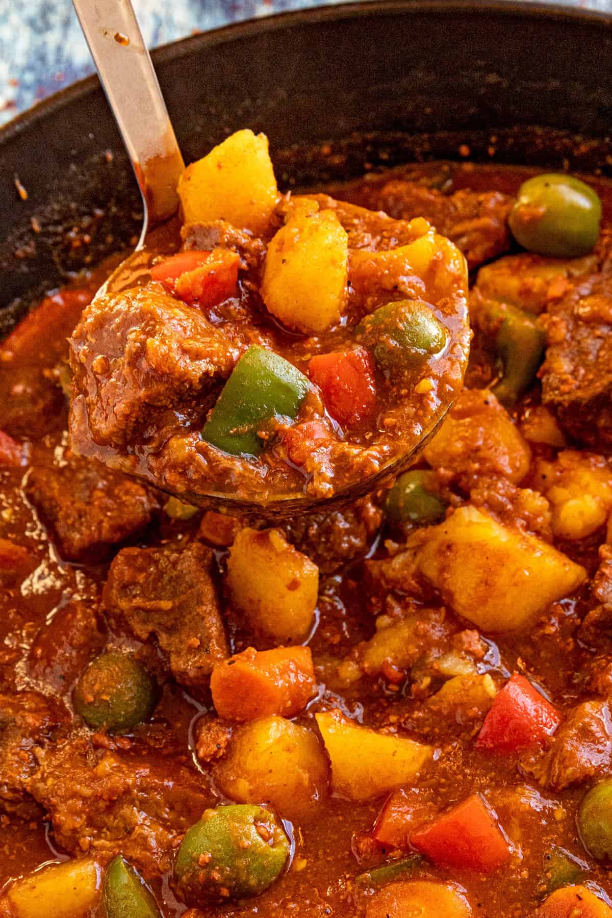 Serving a large ladle full of Beef Caldereta (Filipino Beef Stew) from the pot