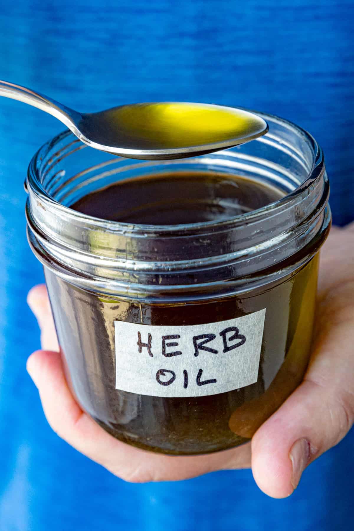 Mike spooning Homemade herb oil from a jar