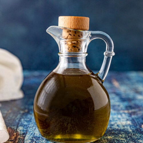 A jar filled with Homemade herb oil, ready to use
