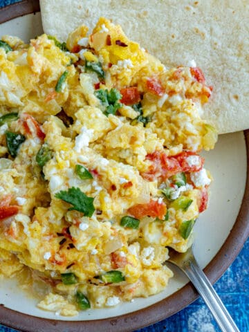 A plate of Huevos a la Mexicana served with warmed tortillas