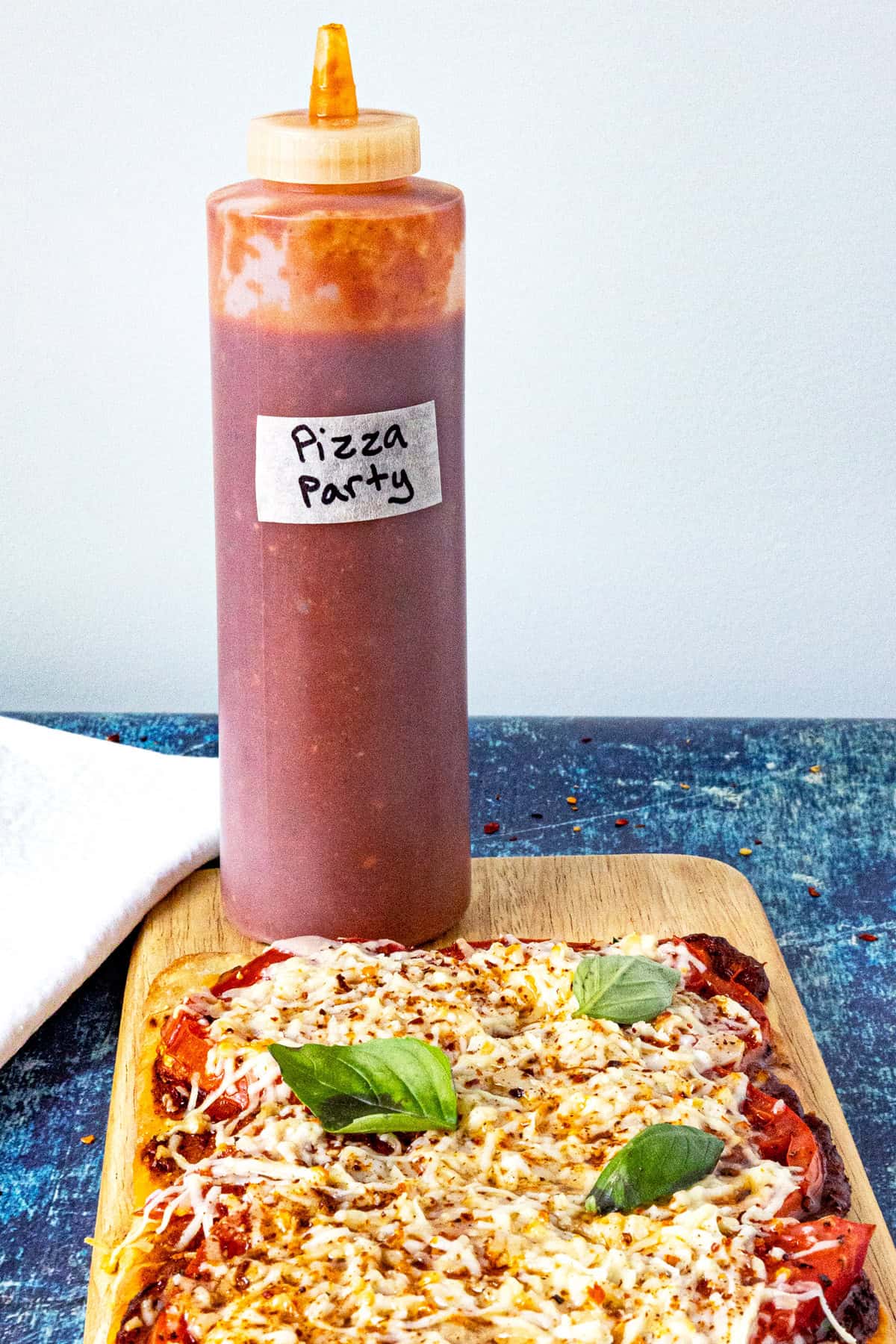 A bottle of Pizza Party Hot Sauce served with pizza