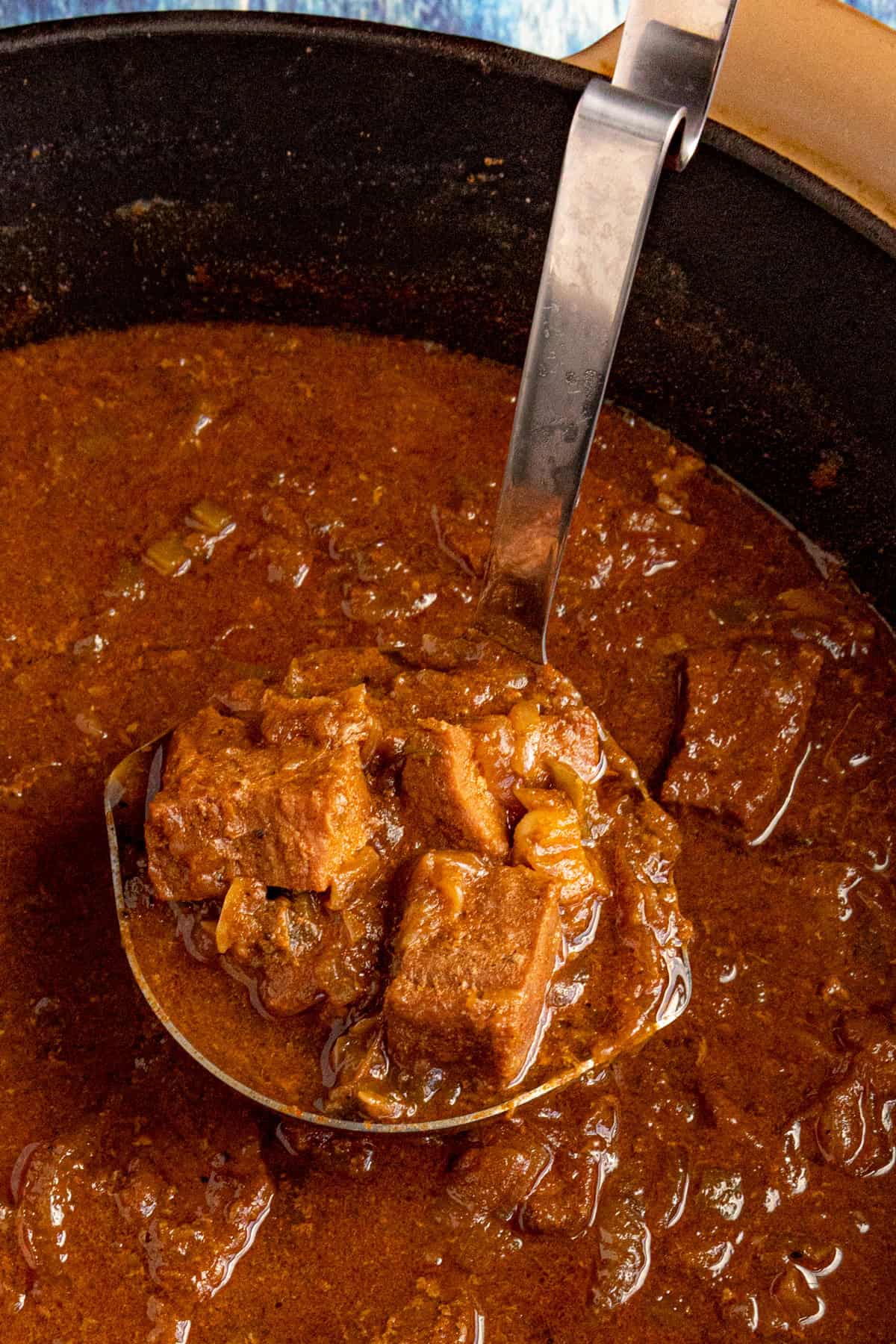 Serving Hungarian Porkolt from the pot with a spoon