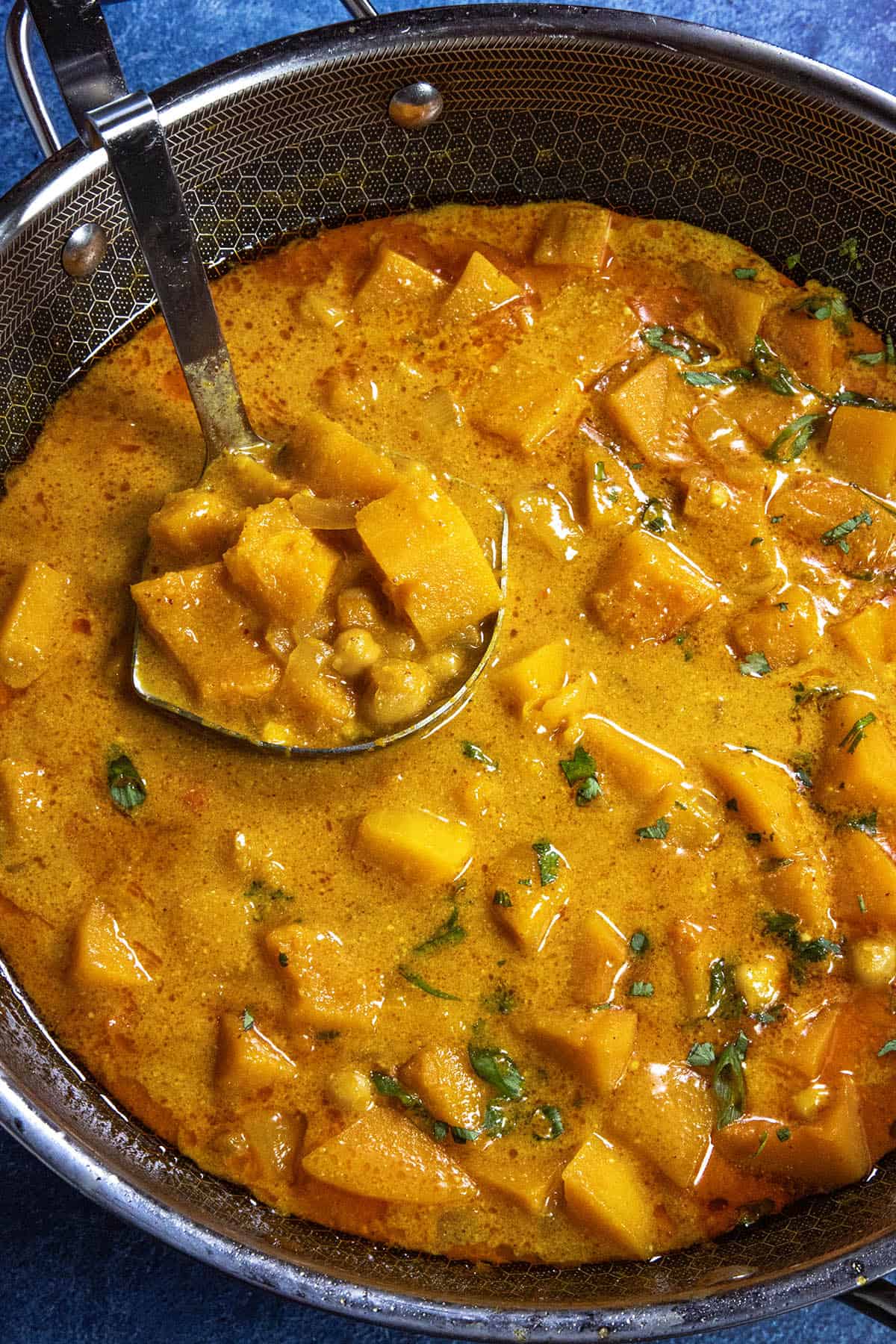 Mike serving a scoop of Butternut Squash Curry from the simmering pot