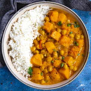 Spicy Thai-style Butternut Squash Curry with Chickpeas in a bowl with rice, ready to serve