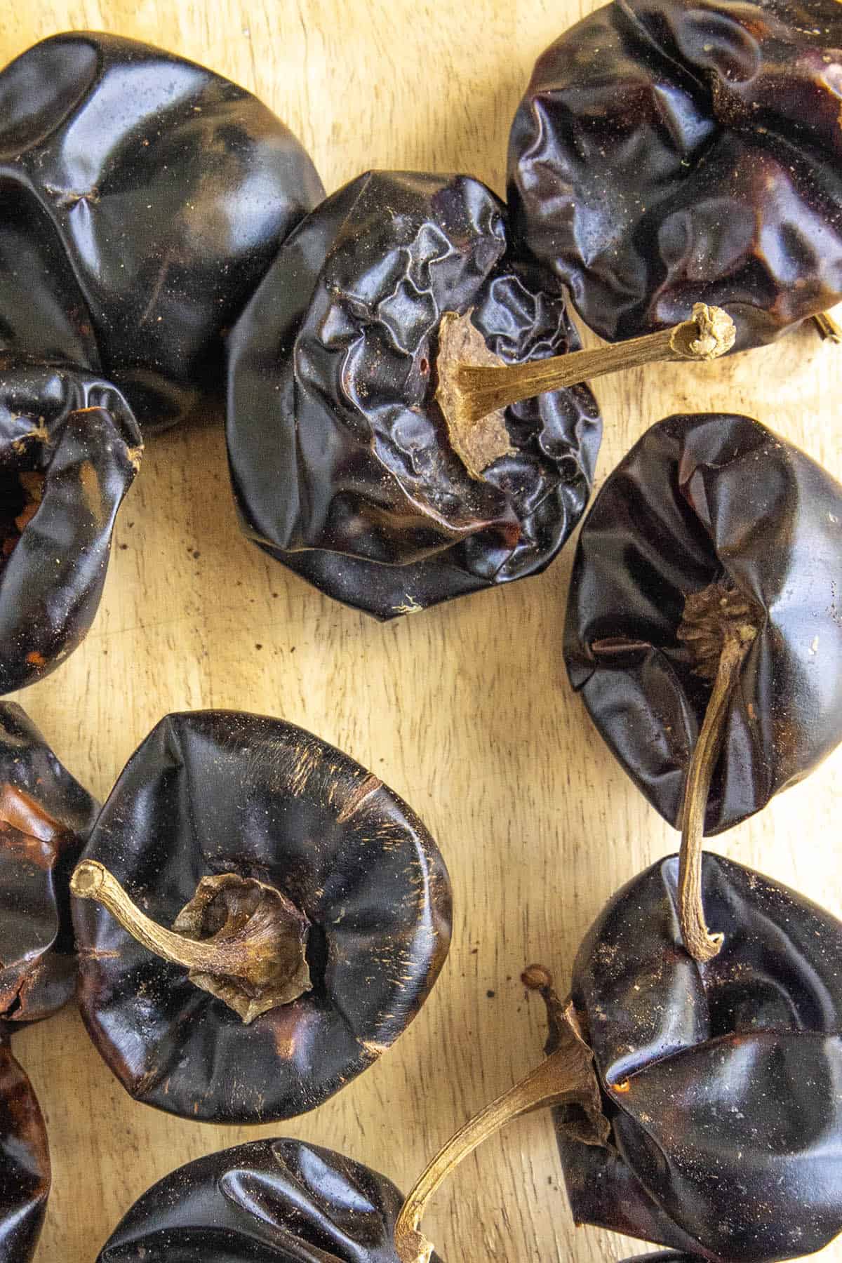 A cutting board loaded with dried Cascabel Peppers (Chile Cascabel)
