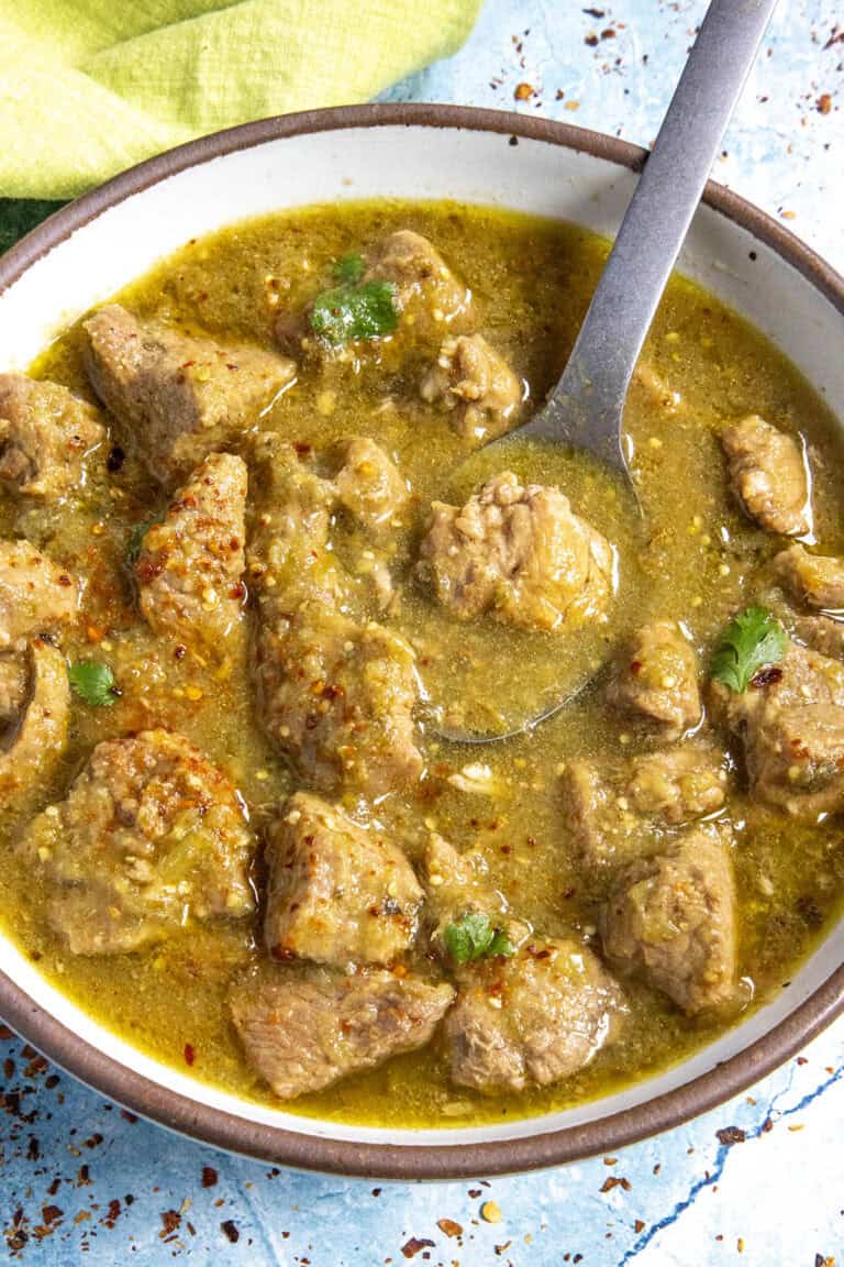 A bowl of chunky Pork Chili Verde, served with a fork