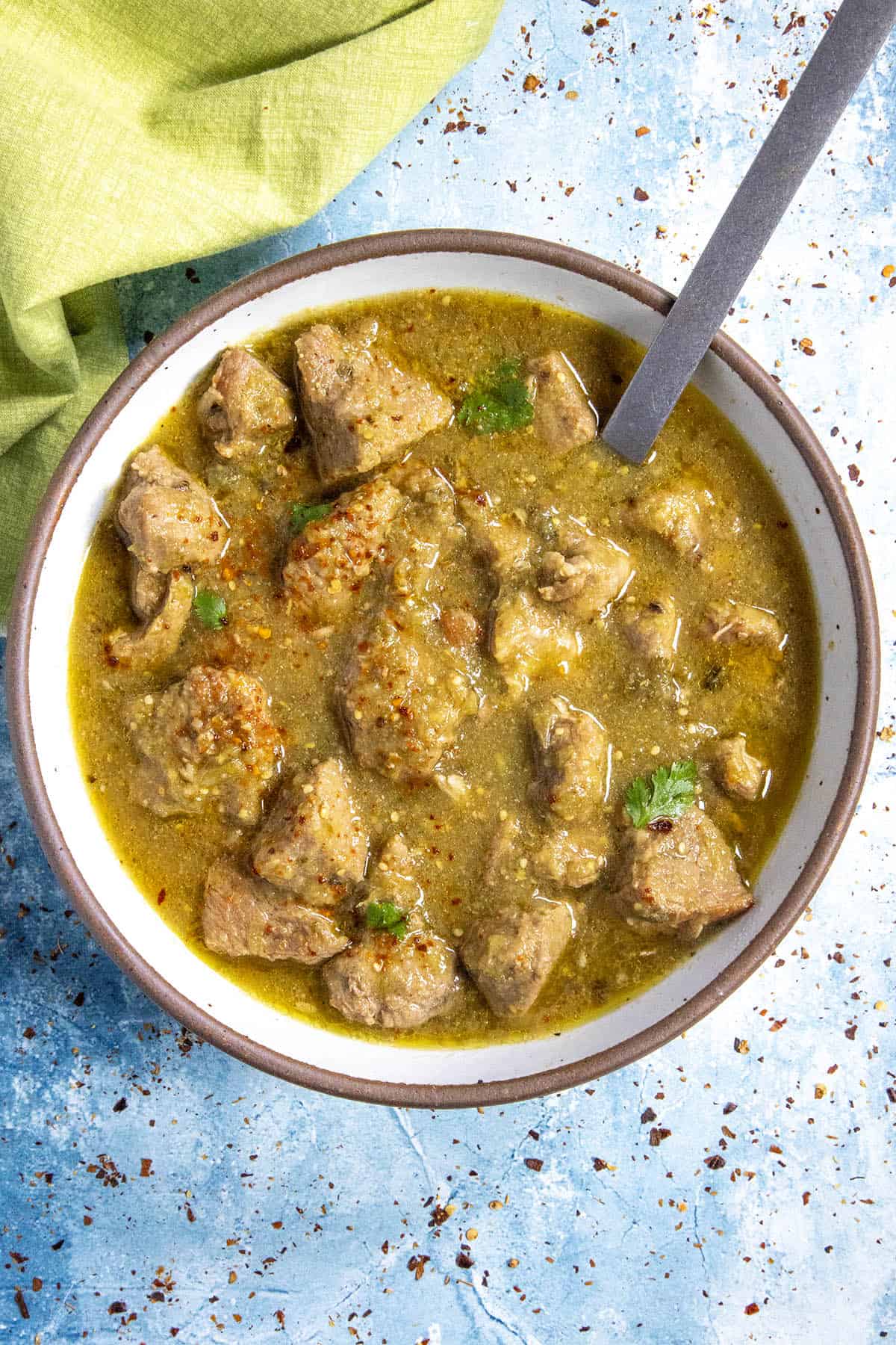 A bowl full of Chili Verde, served with garnish