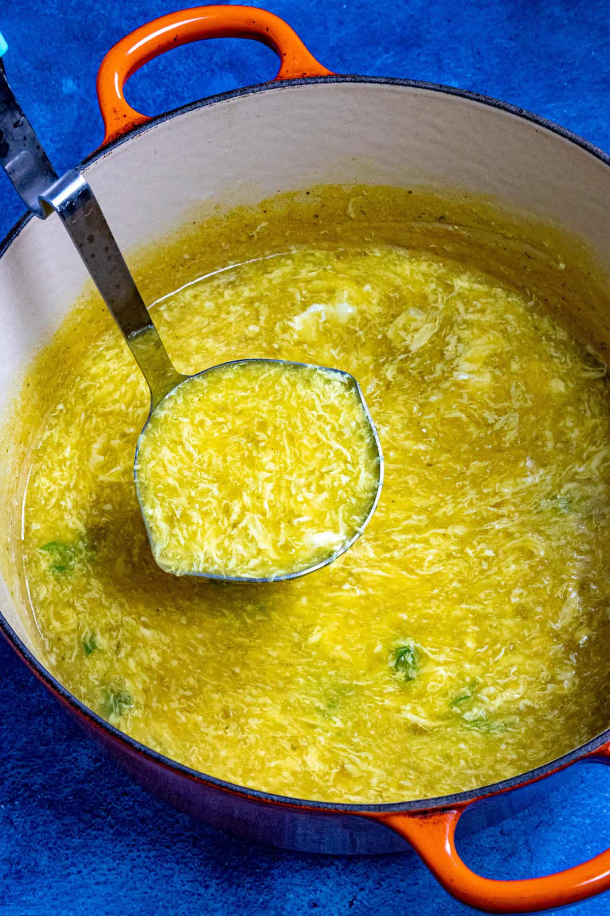 Mike ladling a scoop of egg drop soup from the pot