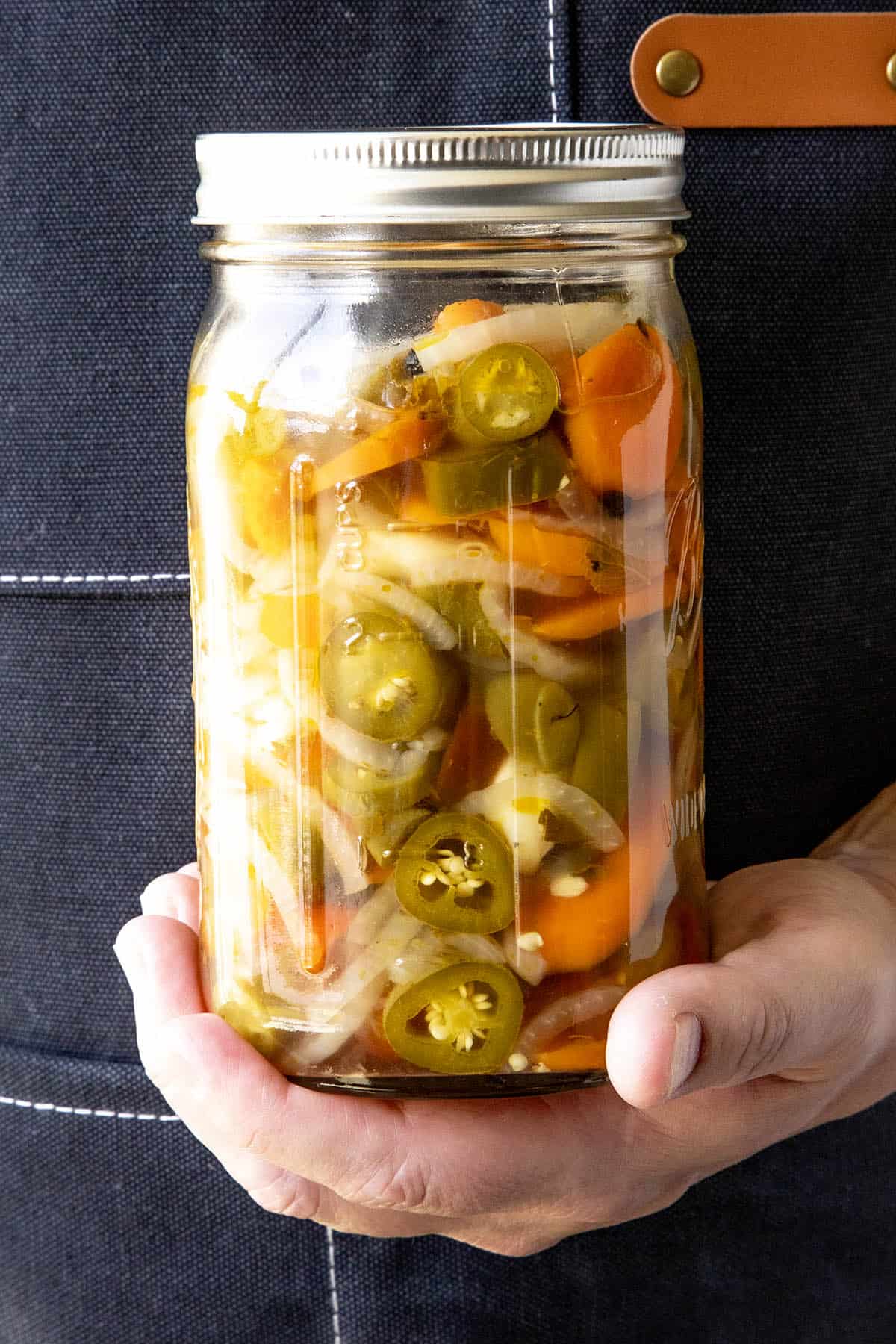 Mike holding a jar filled with Mexican Pickled Vegetables (aka Escabeche)
