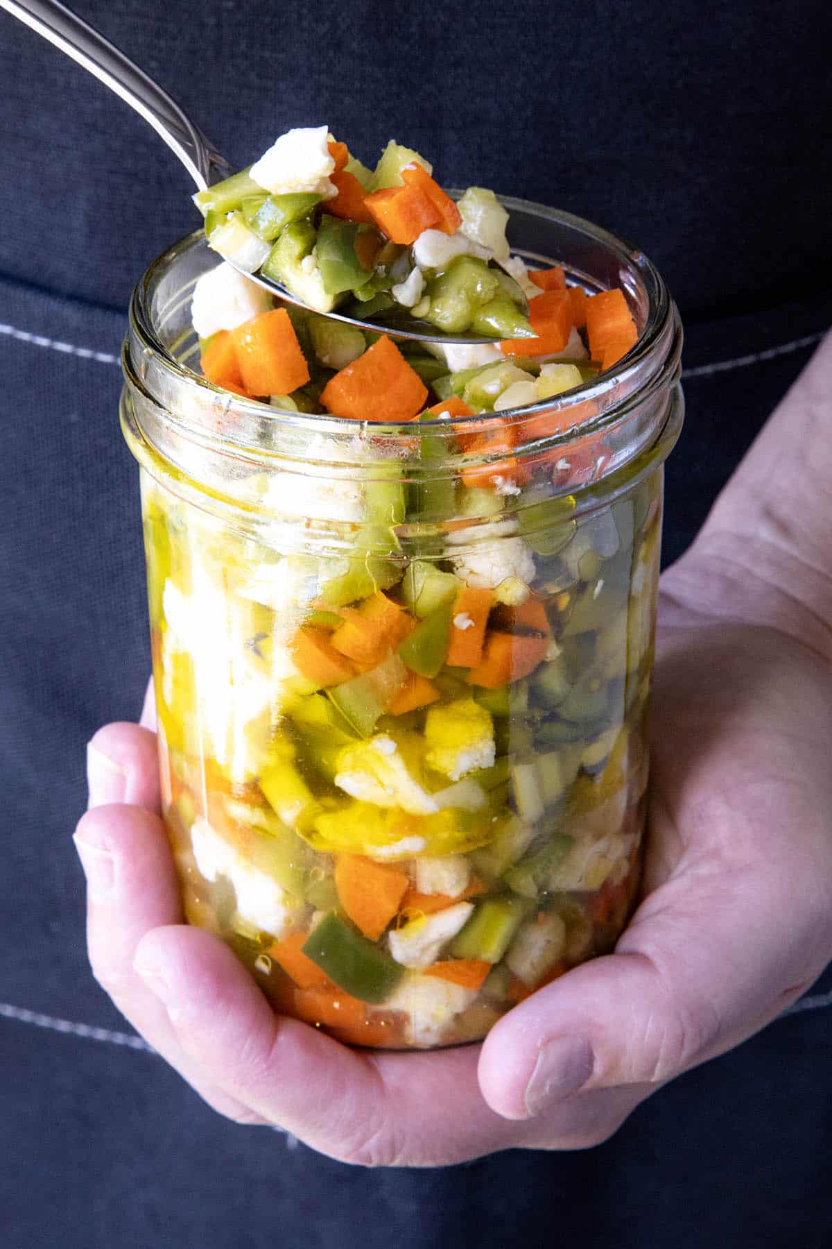 Mike taking a scoop of Chicago-Style Giardiniera from a jar