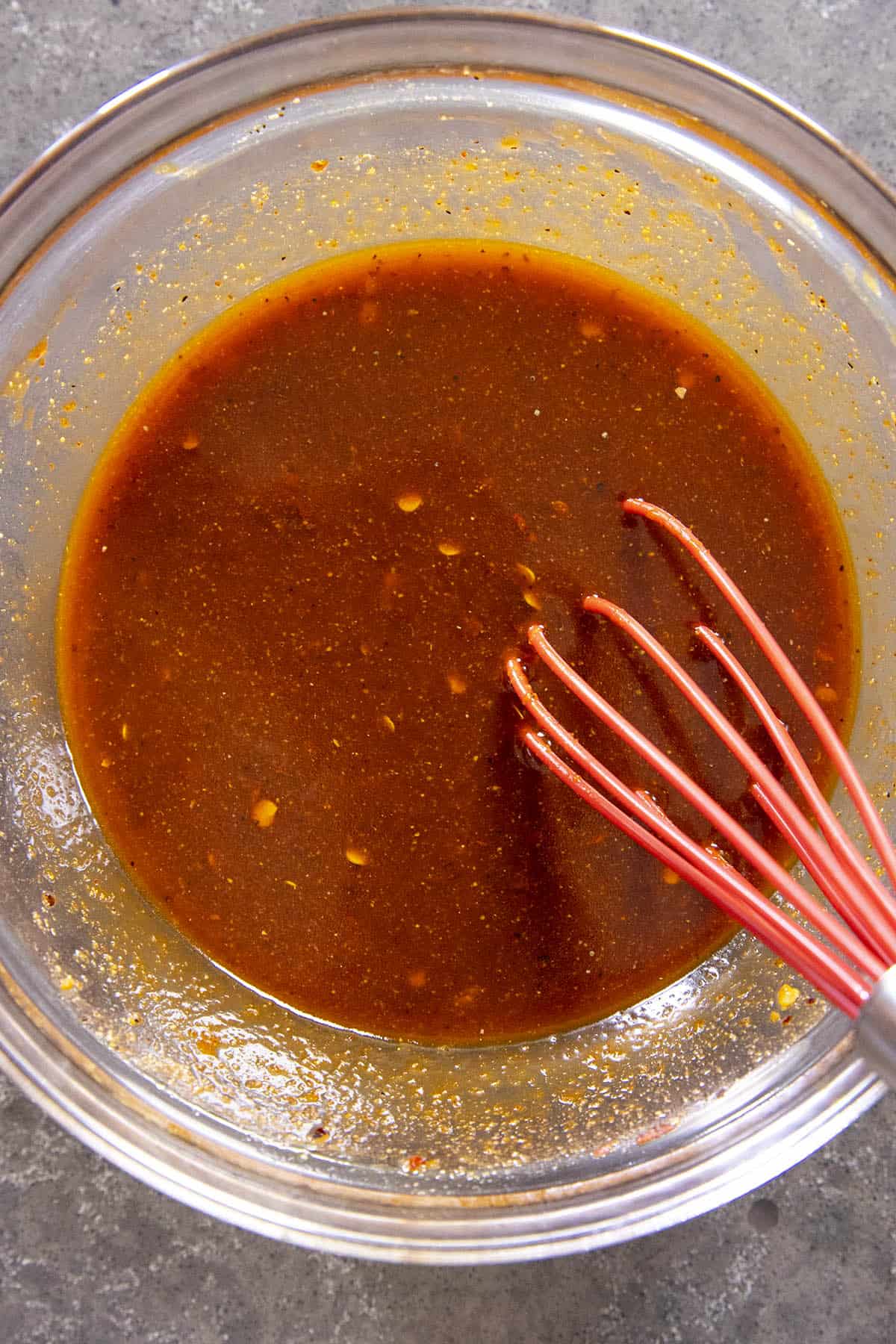 Whisking gochujang stir fry sauce in a bowl to make Gochujang Chicken