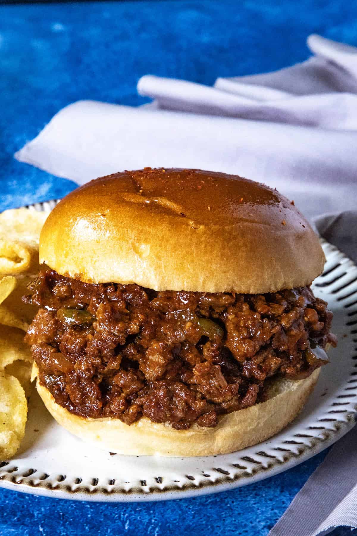 Saucy and spicy Gochujang Sloppy Joes served with potato chips on a plate