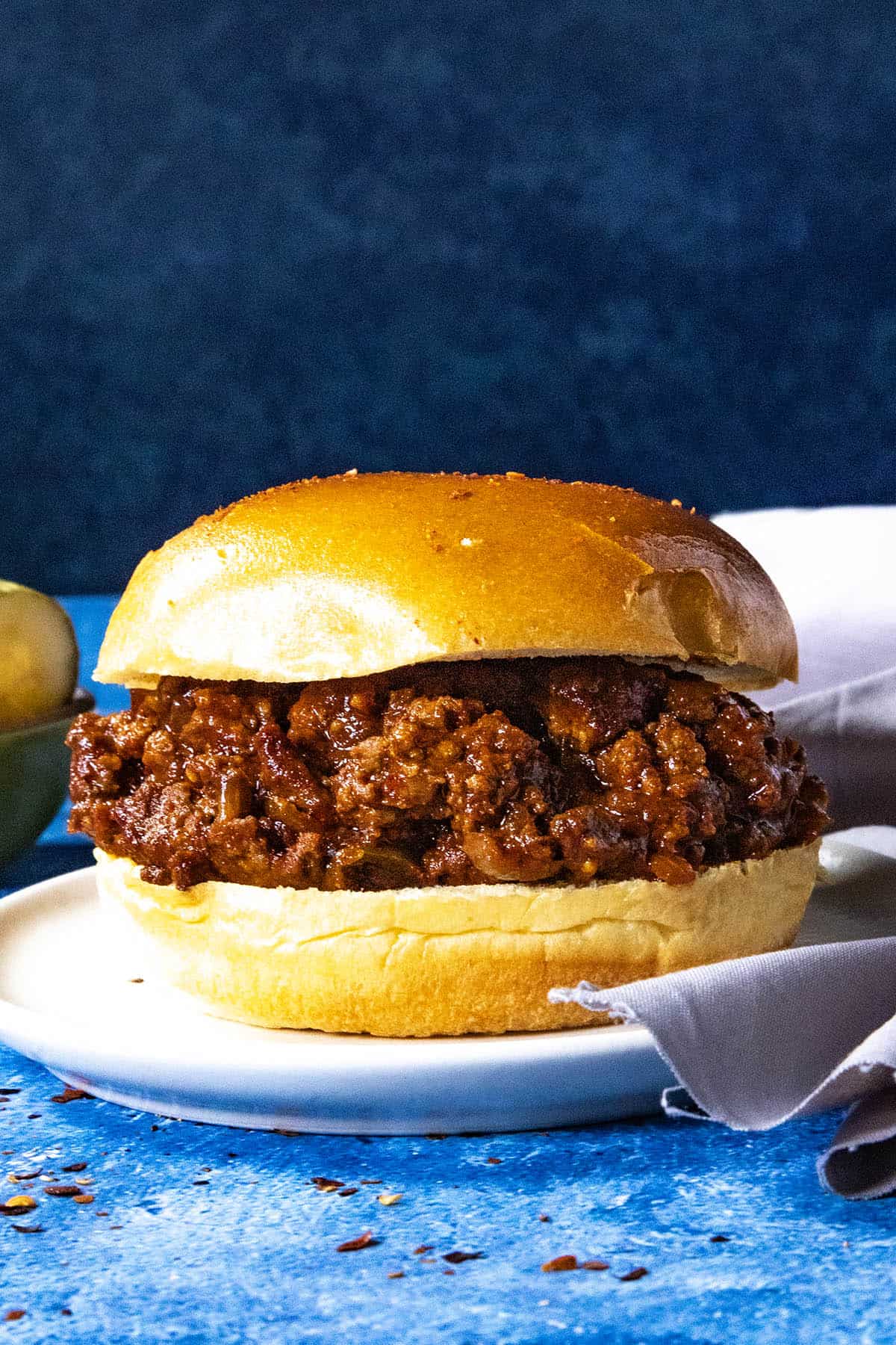 A Gochujang Sloppy Joes sandwich on a soft bun with sticky, spicy sauce