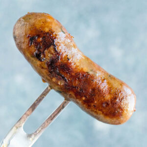 A link of Homemade Italian Sausage pierced with a fork