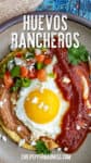 Mexican Huevos Rancheros on a plate, with a sunny-side-up egg served over tortillas with refried beans and ranchero sauce