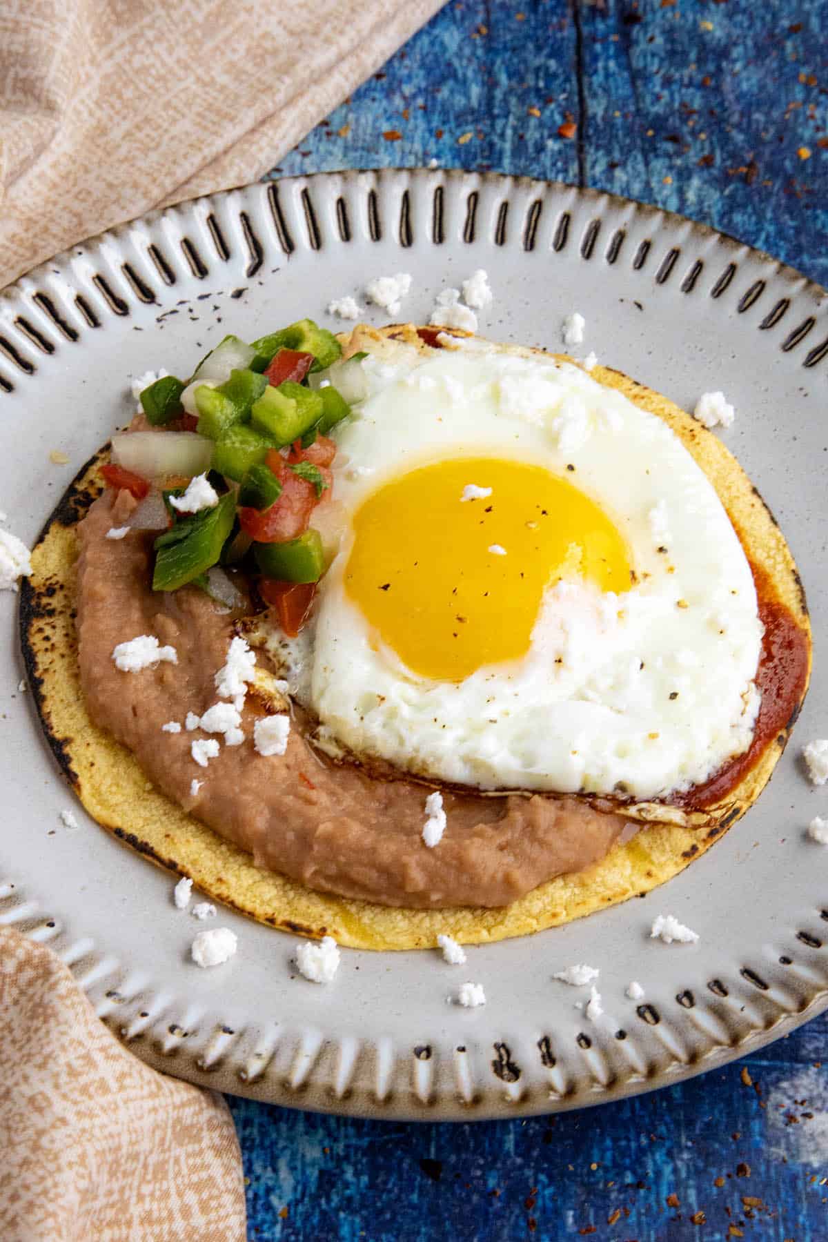 Mexican Huevos Rancheros - a sunny-side-up egg served over tortillas with refried beans and ranchero sauce and pico de gallo.