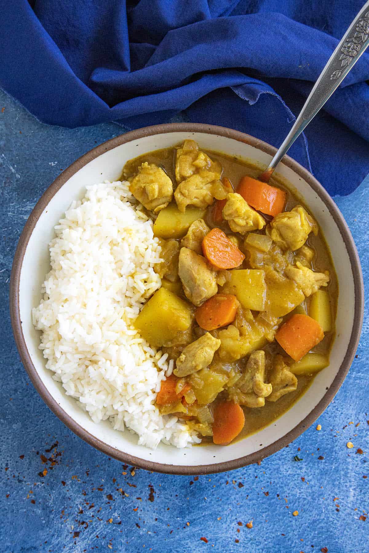 Japanese curry served in a bowl with rice, loaded with chunks of chicken, potatoes, and carrots