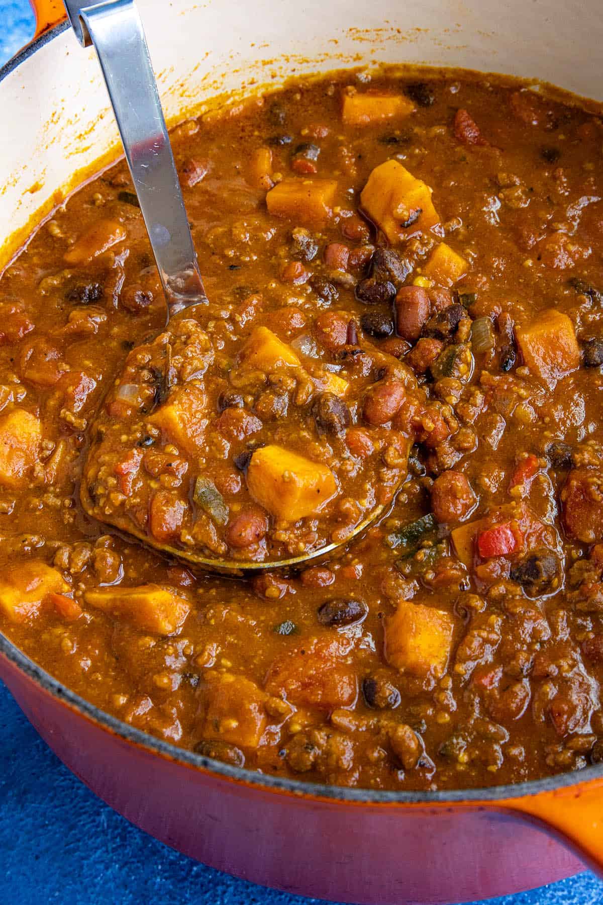 Mike taking a scoop of pumpkin chili from the pot