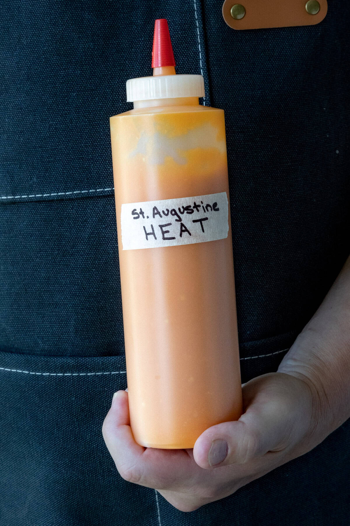 Mike holding a bottle of St. Augustine Heat Hot Sauce