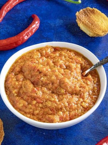 A small white bowl filled with Ajvar (Serbian Roasted Red Pepper Relish), ready to serve