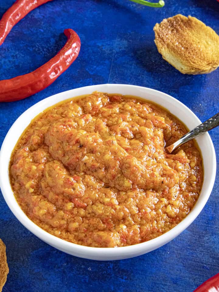 A small white bowl filled with Ajvar (Serbian Roasted Red Pepper Relish), ready to serve