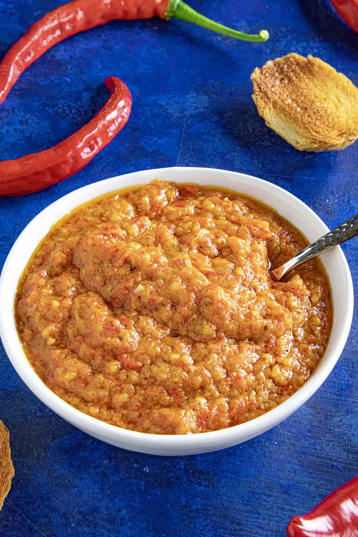 A small white bowl filled with Ajvar (Serbian Roasted Red Pepper Relish), ready to serve