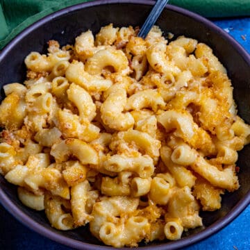 A large bowl filled with Creamy Mac and Cheese with extra cheese, served with a fork