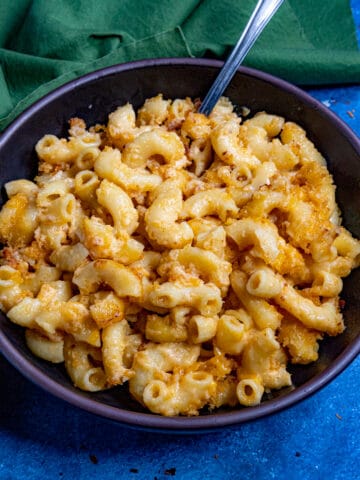 A large bowl filled with Creamy Mac and Cheese with extra cheese, served with a fork