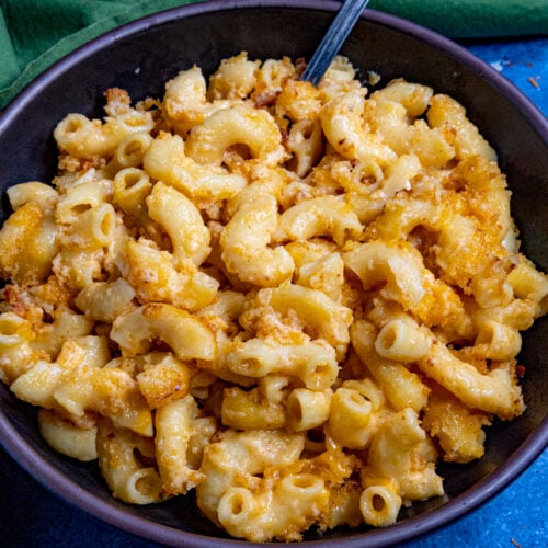 A large bowl filled with Creamy Mac and Cheese with extra cheese, served with a fork