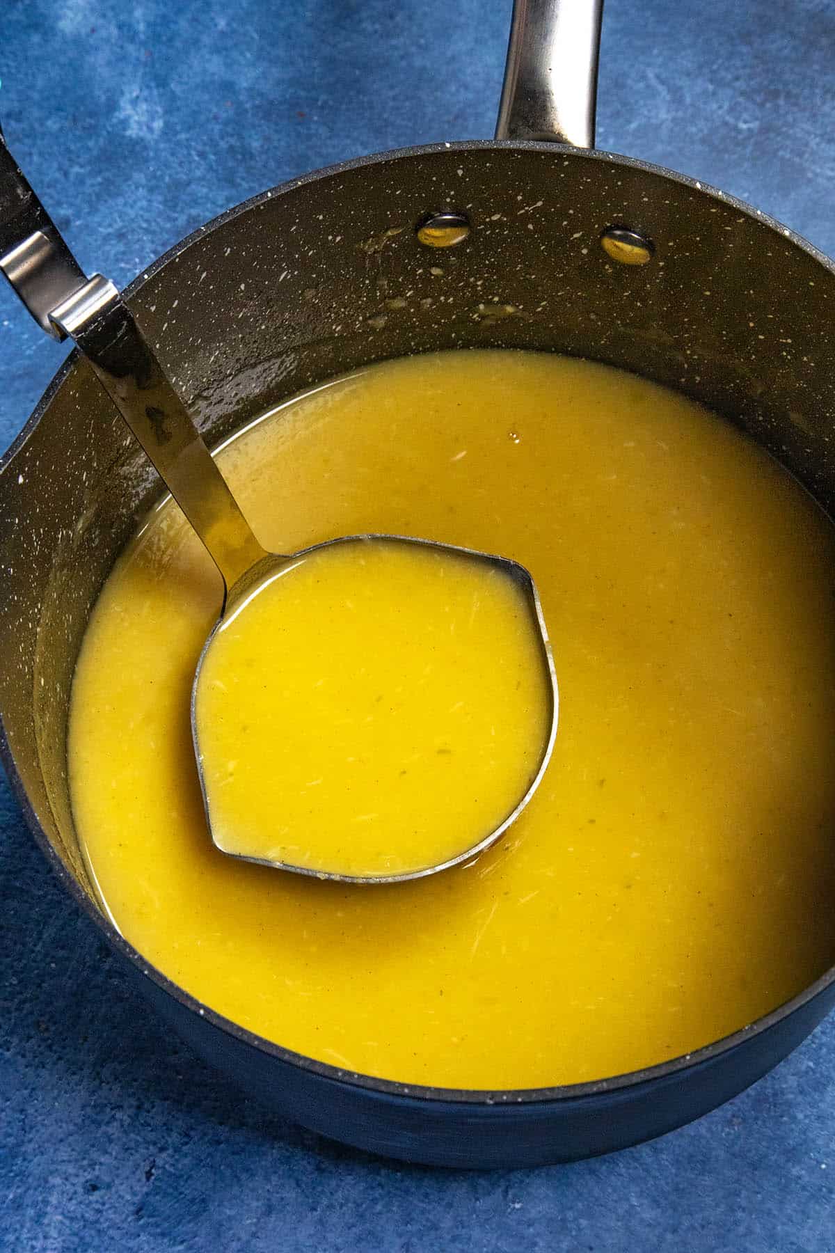 Mike scooping a ladle full of Roasted Garlic Gravy from the pot
