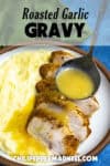 Creamy roasted garlic gravy being drizzled over a plate of turkey with mashed potatoes